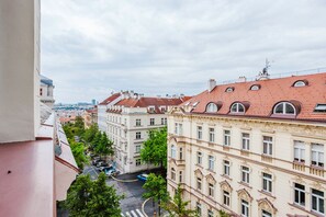 A view of a cityscape with buildings featuring classic architecture and a street with parked cars. - Blueground residence Prague 2  (Prague)