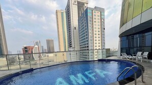 A rooftop pool with a clear view of surrounding high-rise buildings. - Lovely Sea View Studio in Downtown F285O (Seef)