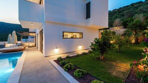 A modern two-story building with a swimming pool, outdoor seating, and a well-maintained garden. - Vrbo Property (Kalkan)
