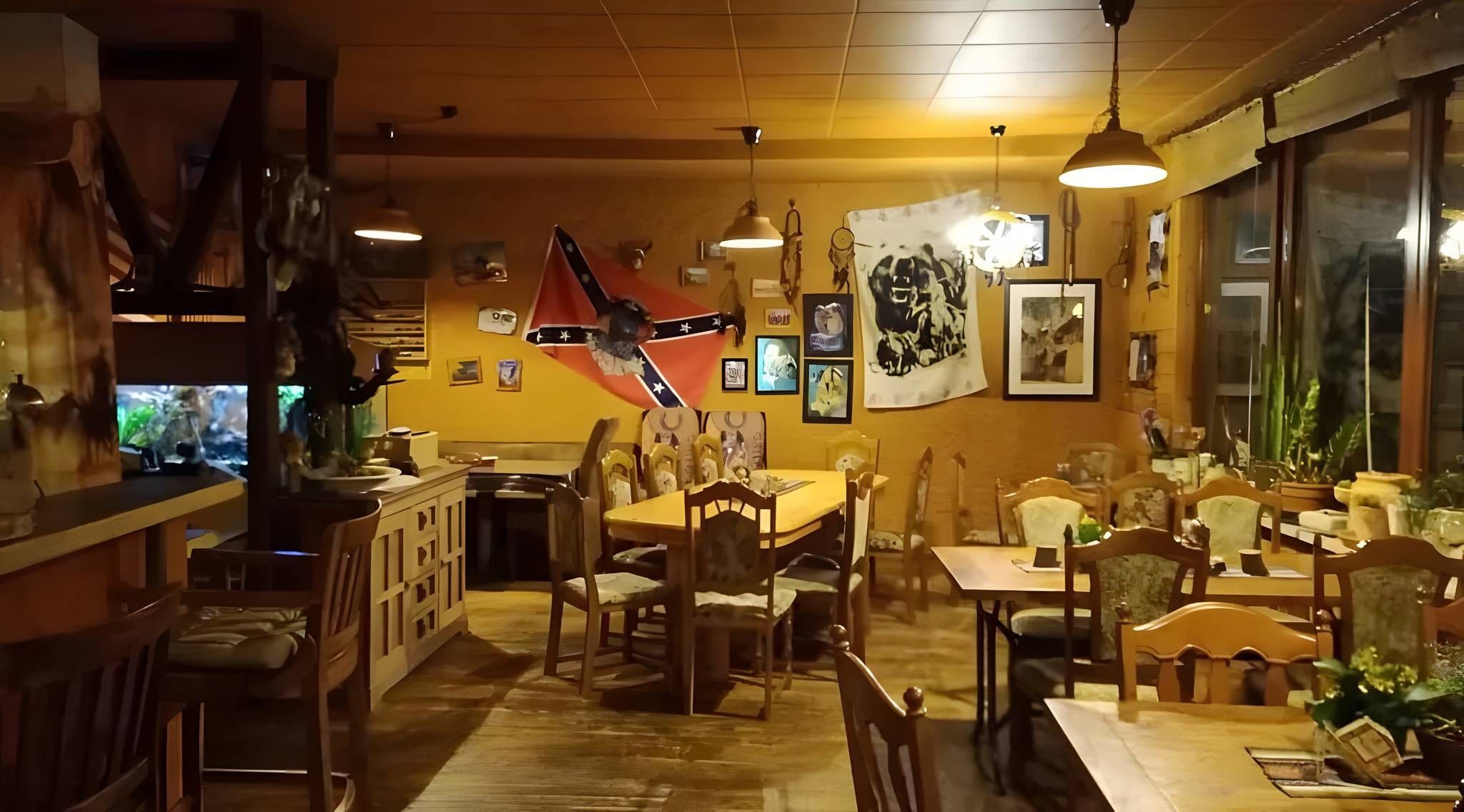 Ein Restaurantinneres mit Holztischen, einer Flagge und verschiedenen Wanddekorationen.