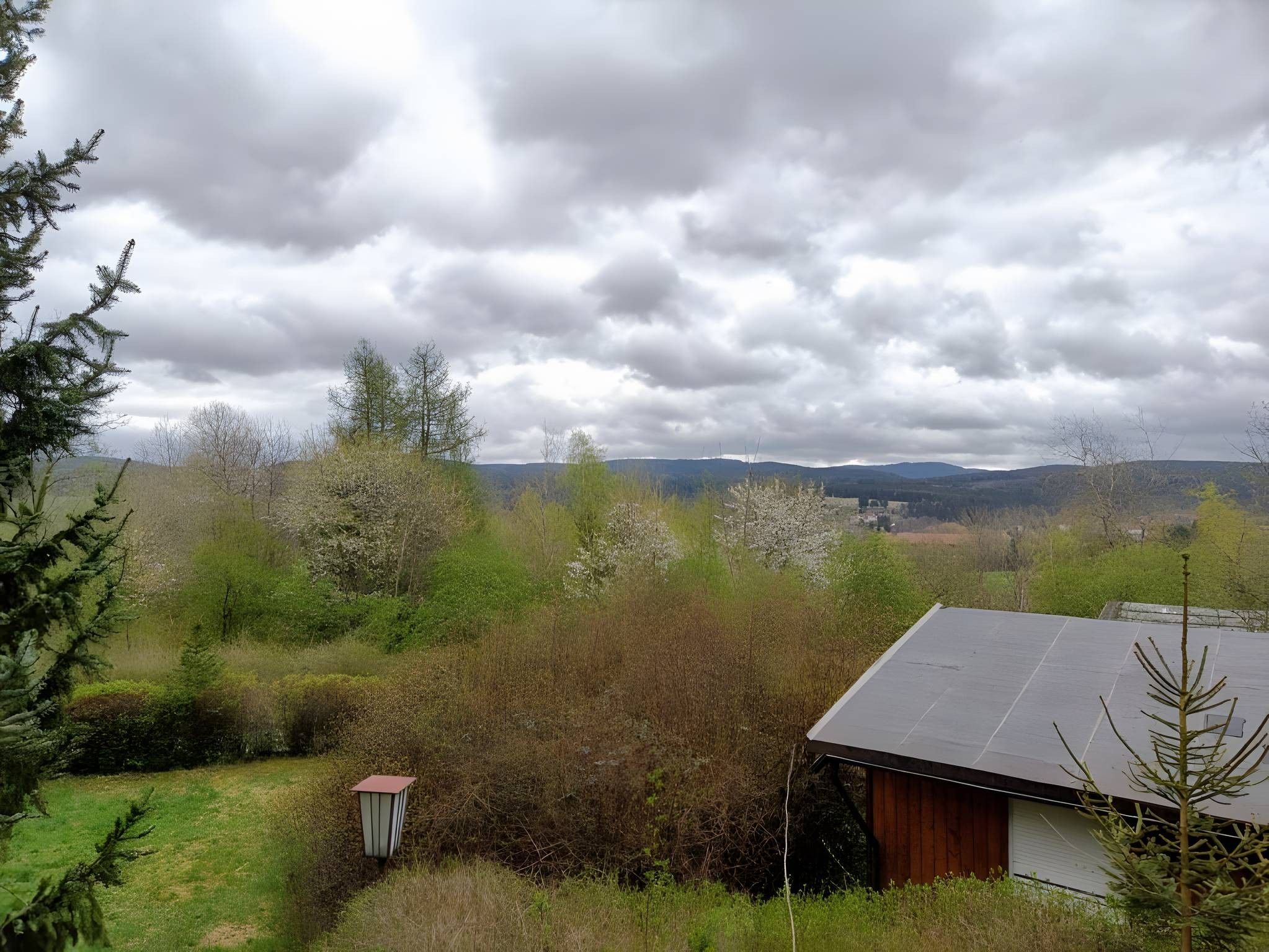 Un paysage rural avec une maison et la végétation environnante.
