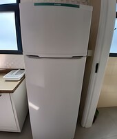 A white refrigerator with a green label in a kitchen.