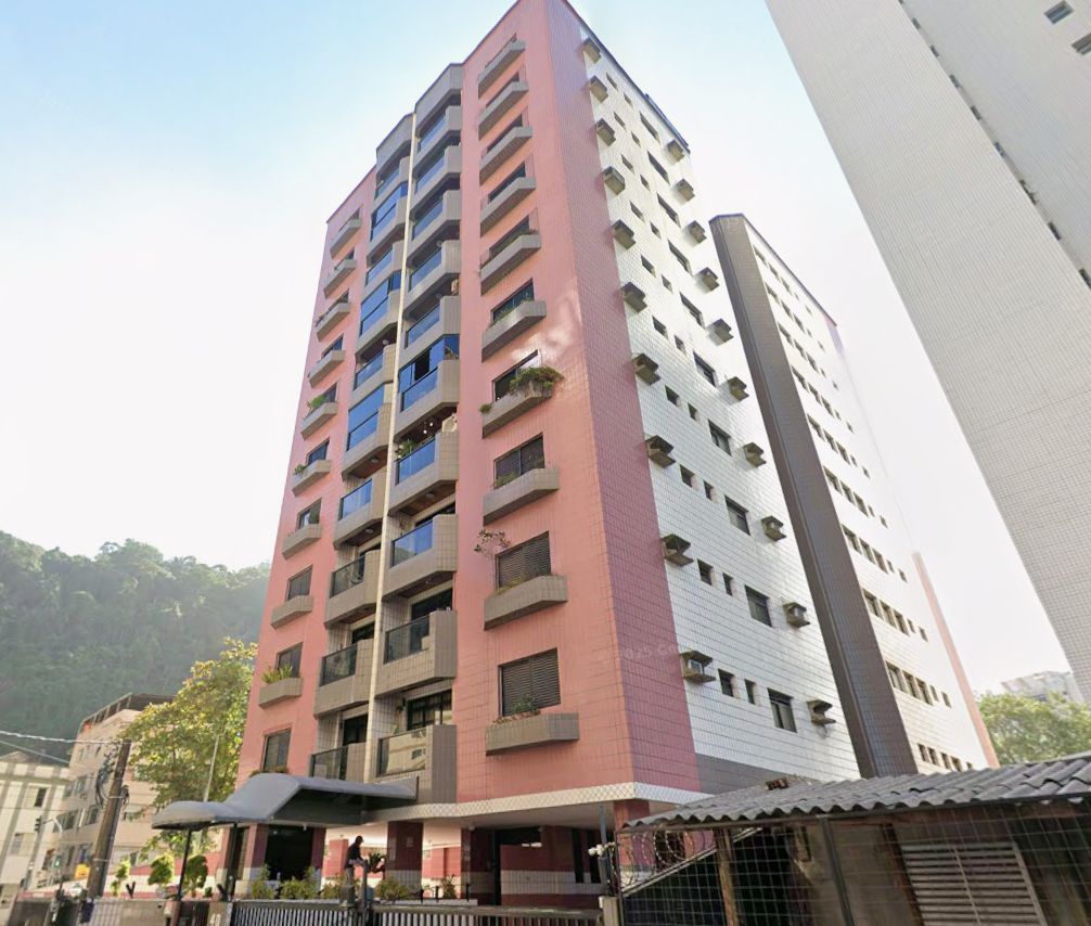 A multi-story building with balconies and a mix of red and white exterior.