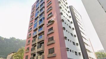 A multi-story building with balconies and a mix of red and white exterior.