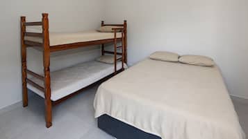 A bunk bed with a lower bunk and a single bed with a mattress and pillows.