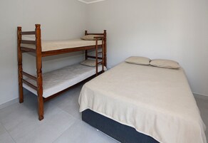 Una cama litera con una cama inferior y una cama individual, con colchón y almohadas.
