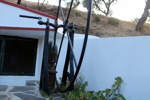 A building with a white exterior and a red roof. There are two black pipes attached to the building, one of which is connected to a valve. - Holiday Home 'Casa Dos Currais' with Mountain View, Wi-Fi and Air Conditioning (Cachopo)