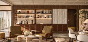 Una sala moderna con una estantería, dos sillones, una mesa de centro y una mesita auxiliar.