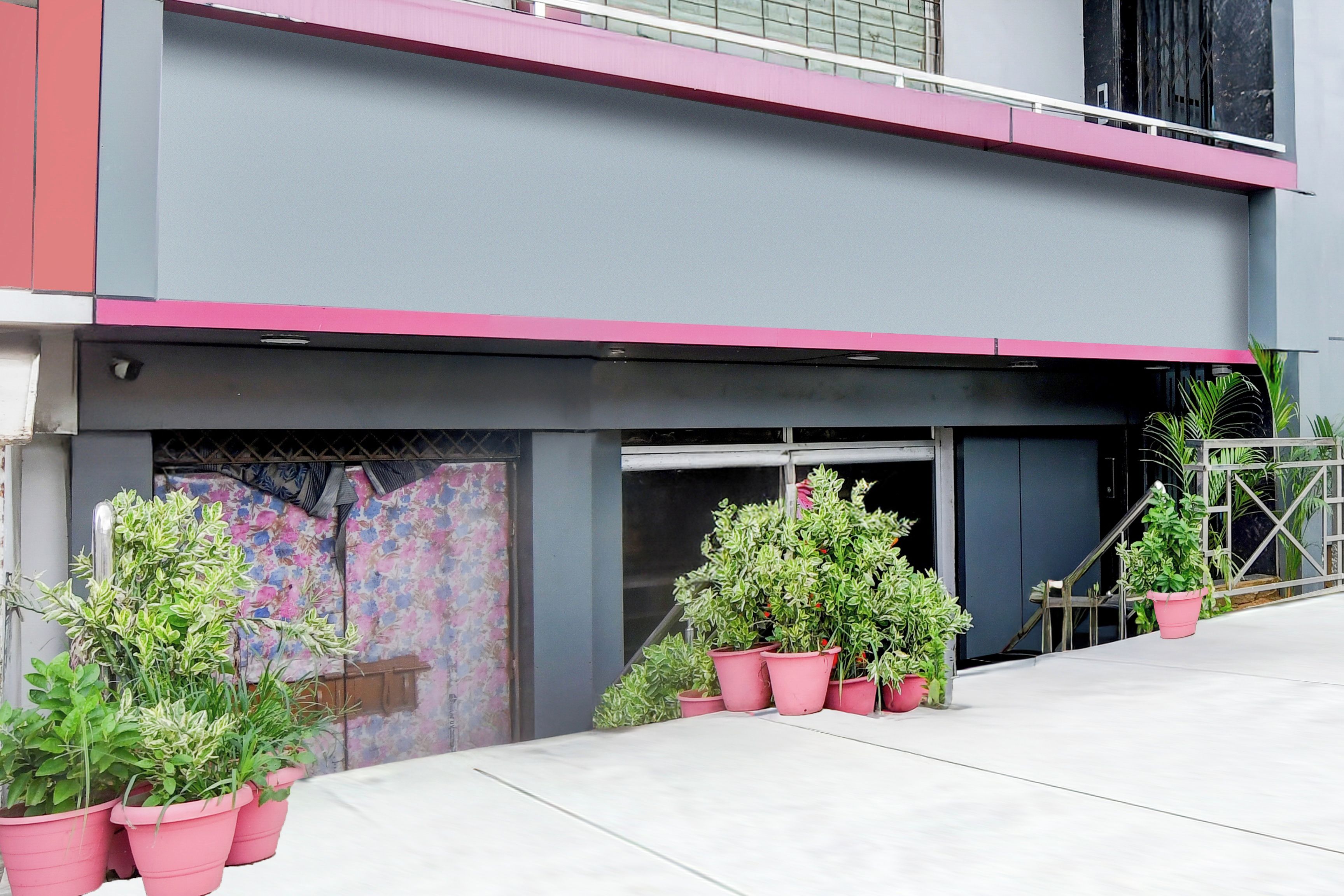 Un edificio con fachada plana, puerta de garaje y plantas en macetas.