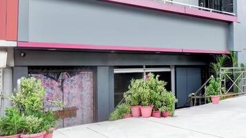 Un edificio con fachada plana, puerta de garaje y plantas en macetas.