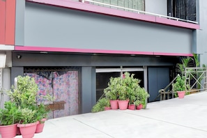 A building with a flat facade, a garage door, and potted plants.