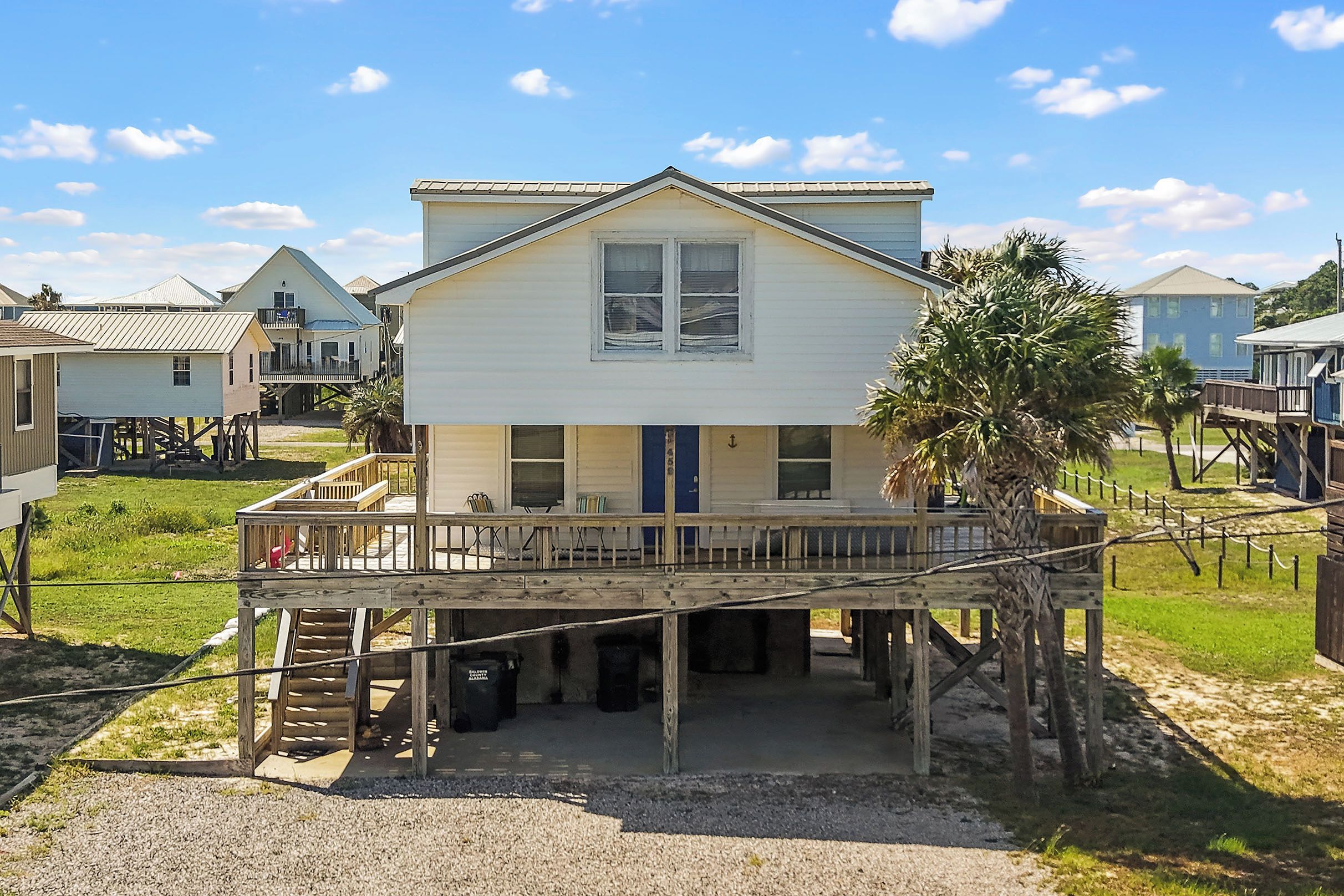 A two-story house with a balcony and a covered porch area.