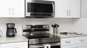 A kitchen with a microwave, oven, and coffee maker. - Bella Vida Family Escape Near Disney (Kissimmee)