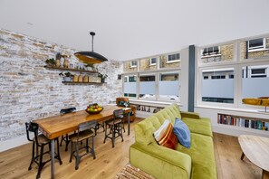 A dining area with a wooden table, chairs, and a bowl of fruit. - Stylish Hove Mews | Close to Beach & Station - Pass the Keys (Hove)