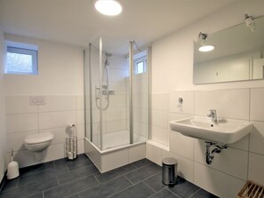 A modern bathroom with a glass-enclosed shower, a white sink, and a toilet. - Holiday Home With 2 Bedrooms (Wyk auf Foehr)