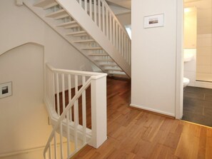 Eine Treppe mit weißen Geländern, die zu einer zweiten Etage führt.