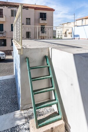 Una escalera metálica verde que conduce a la entrada de un edificio.