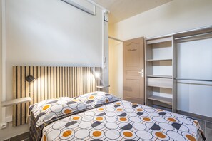 Ein Schlafzimmer mit einem Bett, einem Kleiderschrank und einem Nachttisch.