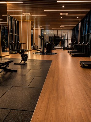 A modern gym with exercise equipment, wooden flooring, and large windows. - Skyline A43A-07 Heart of the city, new (Kuala Lumpur)