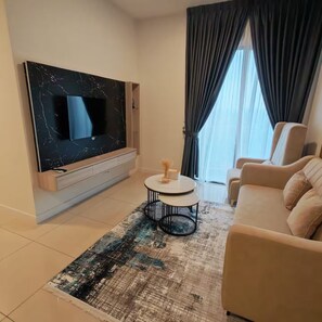 A modern living room with a flat-screen TV, a round coffee table, a beige sofa, and a patterned rug. - Skyline D-27-11, the heart of the city in KL new (Kuala Lumpur)