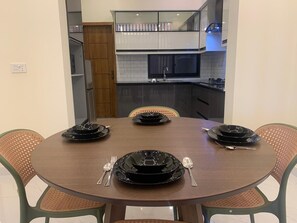 A dining table set with black plates, silverware, and a glass. - Perfect 1-bedroom apartment with AC in soothing Lahore (Lahore)