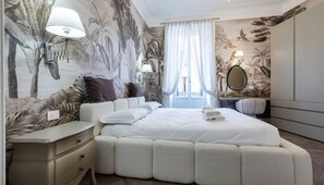 A bedroom with a large bed, a bedside table, a mirror, and a wall with a tropical mural. - Italianway Comfort - Giovio 11 (Milano)