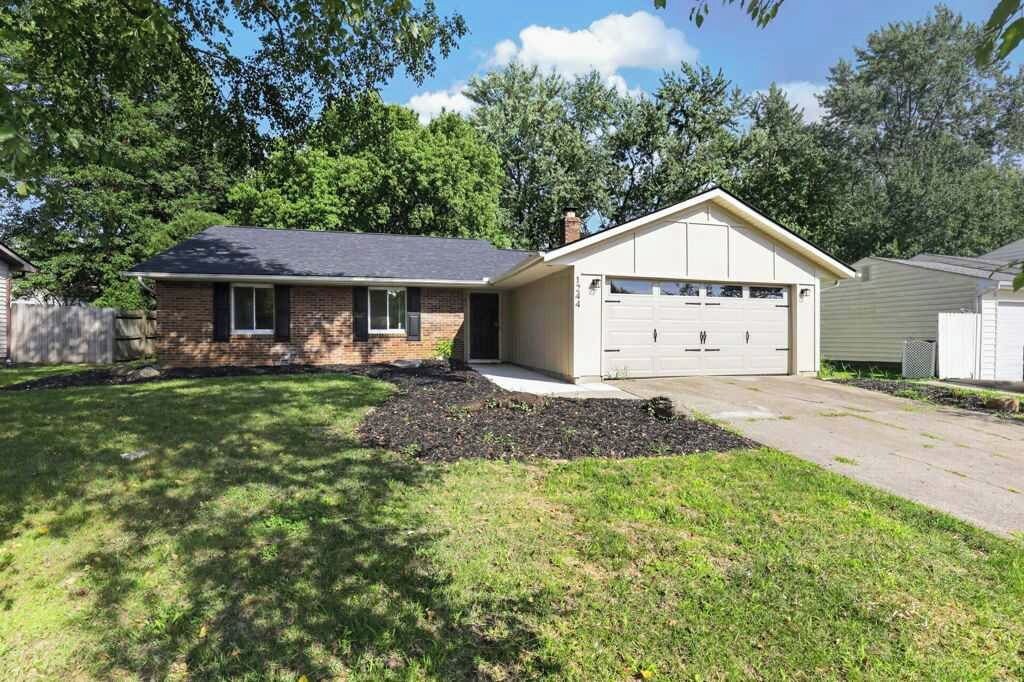 A single-story house with a garage, a front lawn, and a brick exterior.