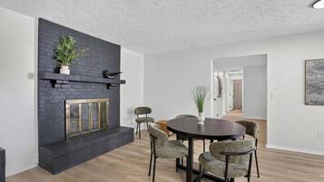 Una sala moderna con chimenea, una mesa de comedor redonda y sillas.
