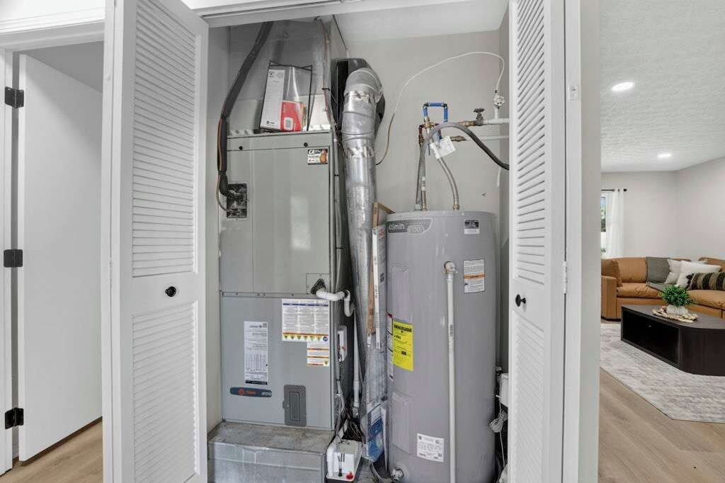 Un cuarto de servicio amplio con calentador de agua, tuberías y sistema de ventilación.