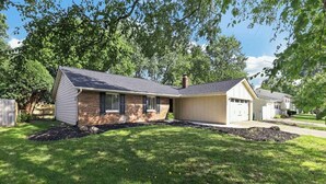 A single-story house with a brick facade and a gabled roof. - Cozy Reynoldsburg Home with Fireplace & Garage (Reynoldsburg)
