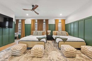 A hotel room with two beds, a ceiling fan, a TV, and a desk with a chair. - FUNtastic Home! | 5 BR - Hot Tub + Game Room! (Columbus)