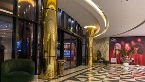 A lobby with a checkered floor, a green armchair, and a large gold pillar. - Best for get away & Peaceful Haven by Flouri F282O (Seef)
