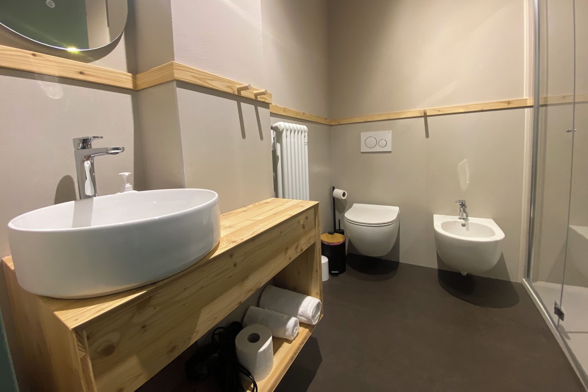 Kylpyhuoneessa on suuri pesuallas, wc-istuin, bidee ja lasinen suihkuseinä.