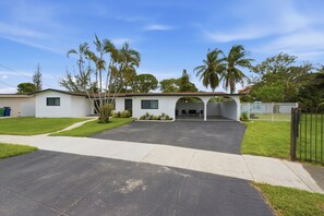 A single-story house with a covered porch, a driveway, and a fenced yard. - Miami Gardens Oasis - Private Pool & Pool Table (Miami Gardens)