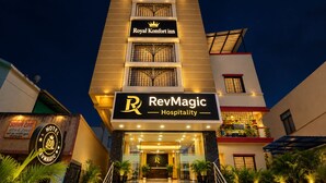Un hôtel avec une enseigne bien visible indiquant « Royal Komfort Inn » et, en dessous, une autre enseigne indiquant « RevMagic Hospitality ».