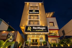 Ein Hotel mit einem gut sichtbaren Schild 'Royal Komfort inn' und einem Schild 'RevMagic Hospitality' darunter.