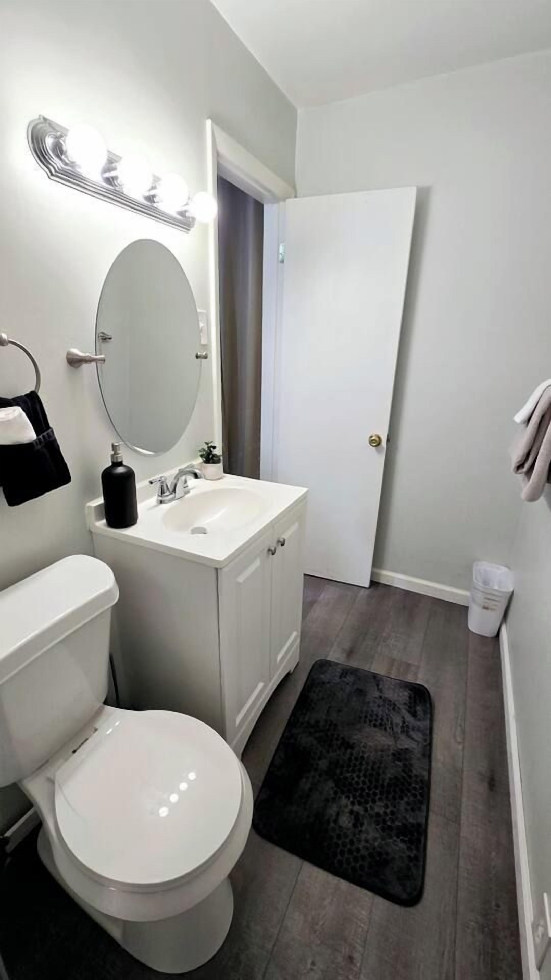 Un baño con inodoro, lavabo, espejo y puerta.