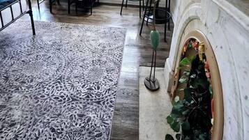 Una sala de estar con chimenea, comedor y un amplio ventanal con cortinas.