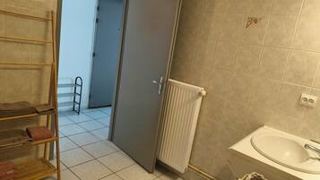 A bathroom with a sink, a towel rack, and a radiator.