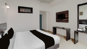 A hotel room with a bed, a desk, a television, and a mirror. - Super Collection O Vaishno Devi Temple (Katra)