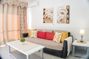 A living room with a sofa, a coffee table, and a lamp. - BenalBeach: Sunny apartment with ocean views (Benalmadena costa)
