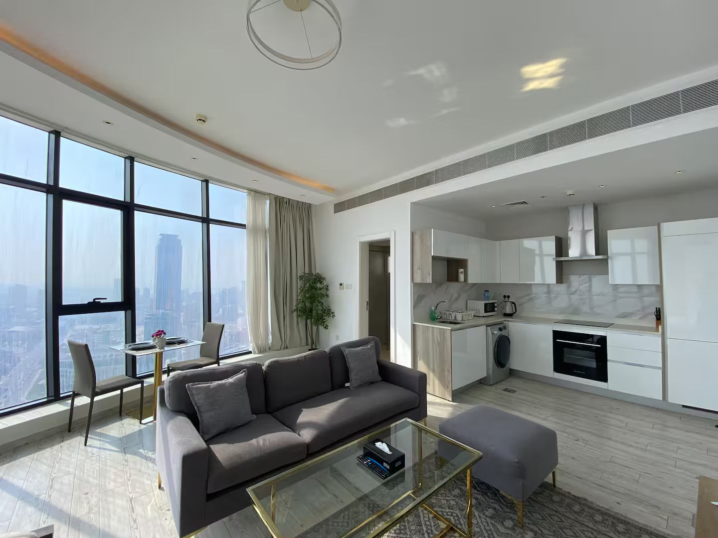 A modern apartment with a living room, dining area, and kitchen.