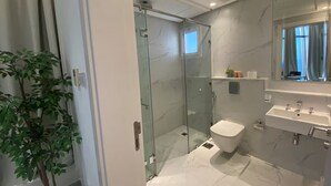 A modern bathroom with a glass-enclosed shower, a white toilet, and a sink with a marble countertop. - Premium Escape with Panorama City View F281O (Seef)