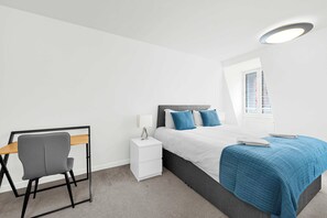 A bedroom with a bed, bedside table, lamp, chair, and a window with blinds. - 6SH  one bed in Holborn sleeps 2 (London)