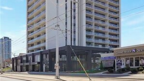 A multi-story building with a modern architectural design, featuring a series of balconies on each floor. - Modern Penthouse in Central KW (Kitchener)