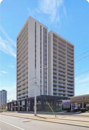 Ein mehrstöckiges Gebäude mit modernem architektonischen Design, das eine Reihe von Balkonen in jeder Etage aufweist.