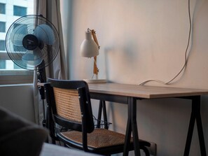 A workspace with a desk, chair, lamp, and standing fan. - Costa Home - MUT Costanera & WIFI & Moderno (Santiago)