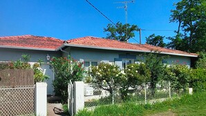 A two-story house with a red-tiled roof, a wooden fence, and various plants in front. - Holiday Home 'Villa L'escale 600 M De La Plage' with Private Terrace and Private Garden (Andernos-les-Bains)