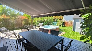 An outdoor patio with a hot tub, wooden deck, and seating area. - Holiday Home 'Villa L'escale 600 M De La Plage' with Private Terrace and Private Garden (Andernos-les-Bains)