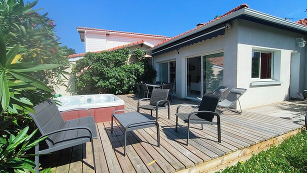 An outdoor deck with a hot tub, seating area, and a covered patio. - Holiday Home 'Villa L'escale 600 M De La Plage' with Private Terrace and Private Garden (Andernos-les-Bains)